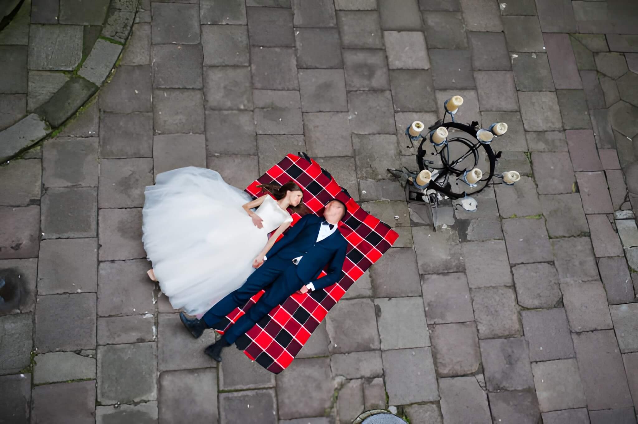 Wedding couple lying on blankets. Photo from quad copter drone view
